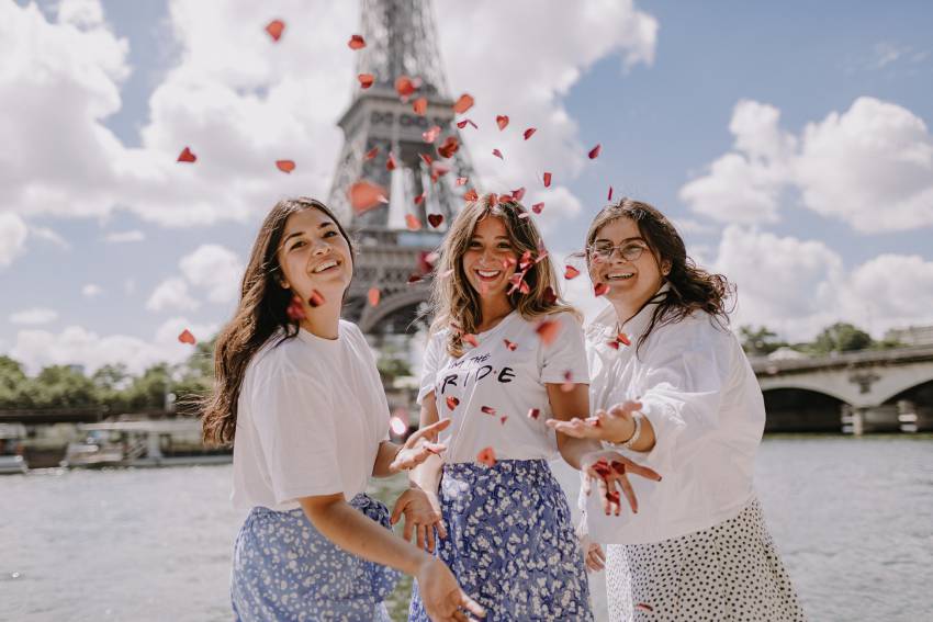 trois jeunes femmes devant la tour eiffel le long de la seine